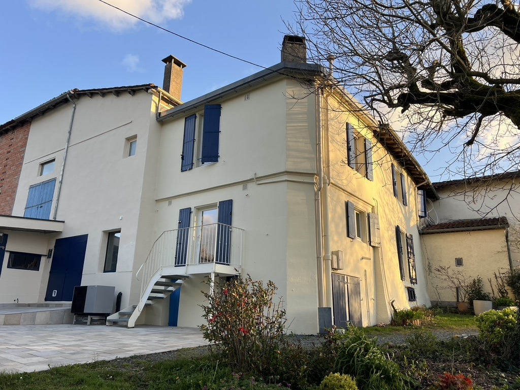 Façade rénovée de maison avec volets bleus par Novela Façades