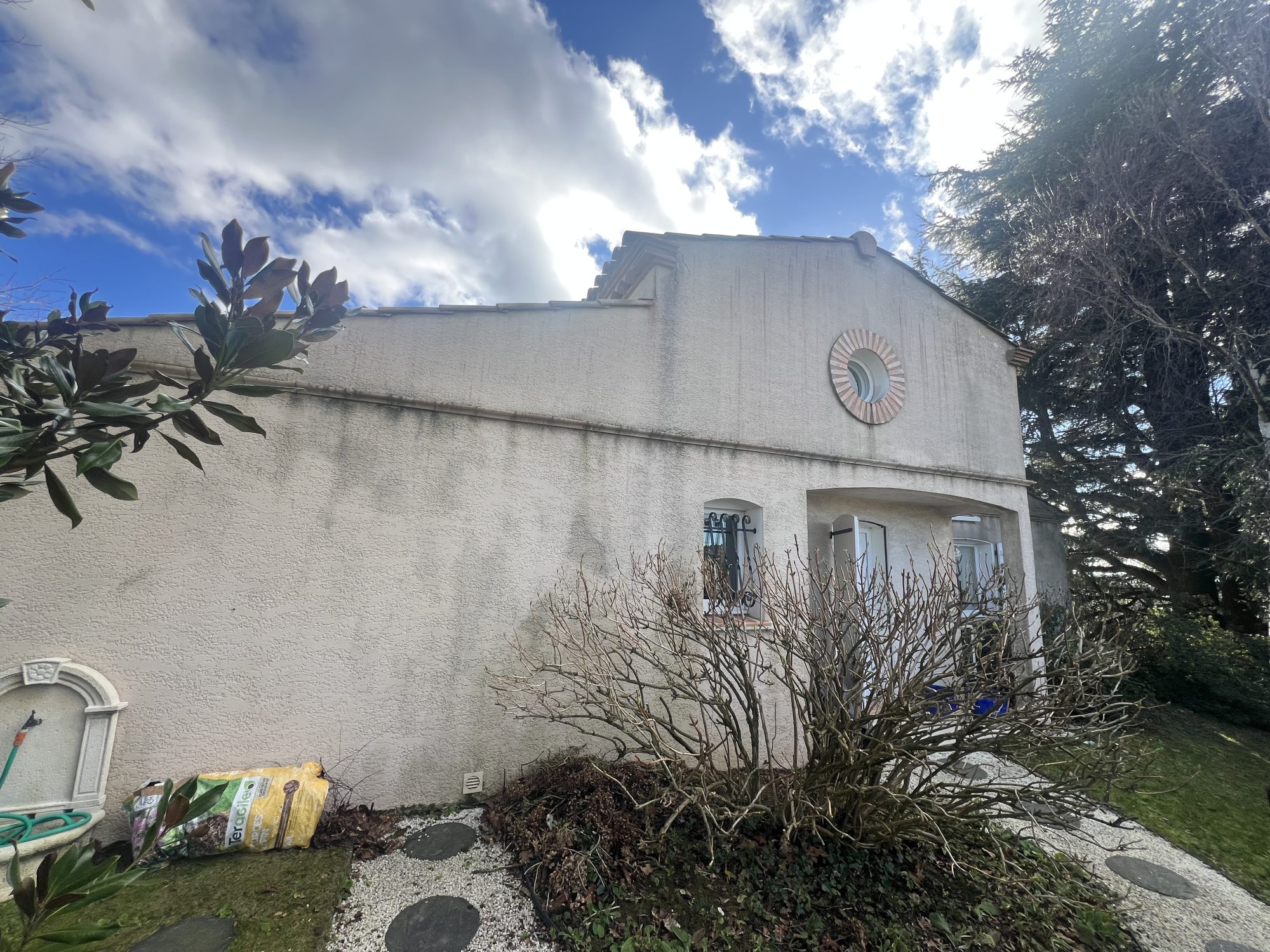 Façade de maison en crépi avec traces d’humidité, rénovation Novela Façades